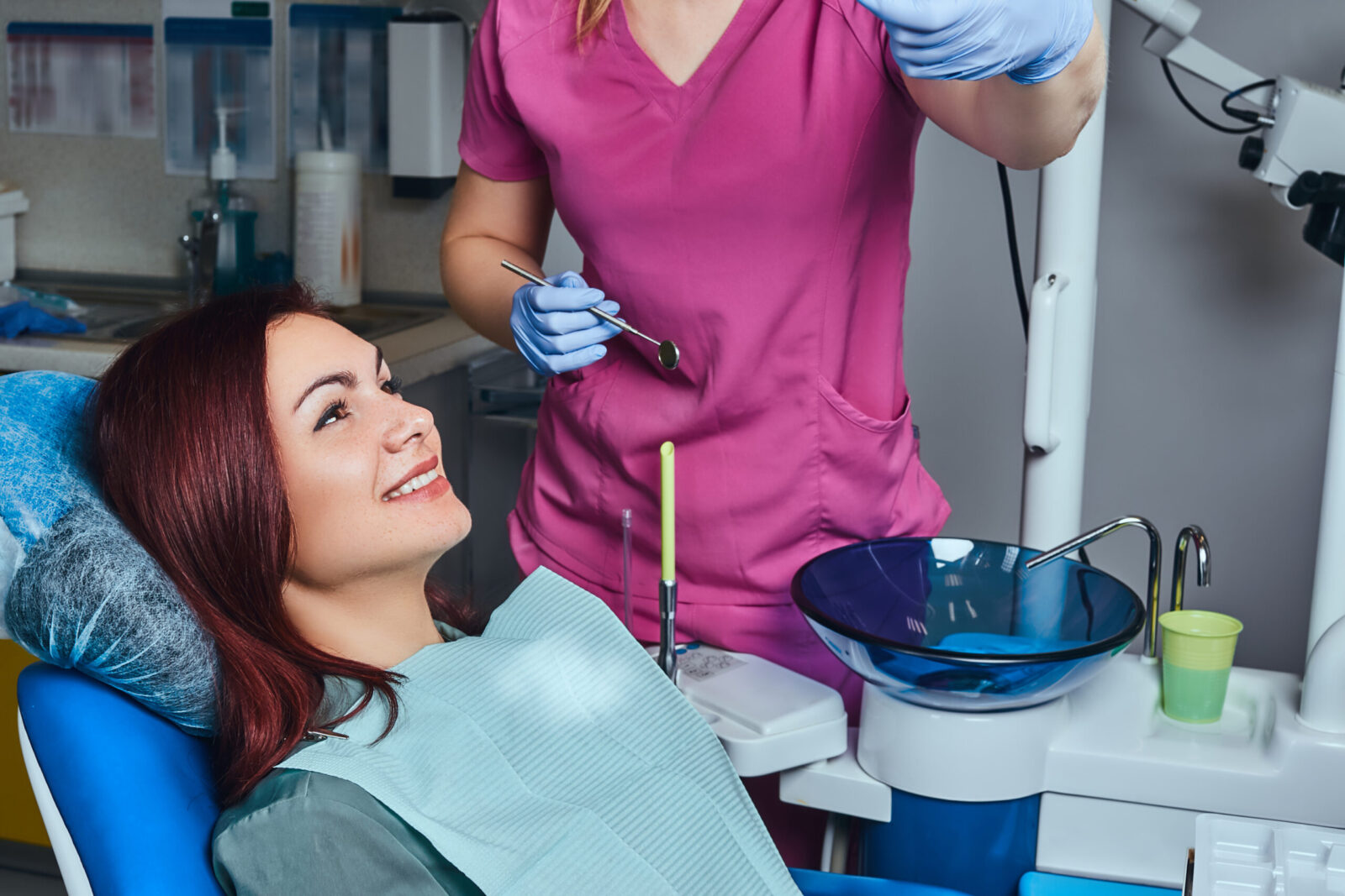 A young smiling woman having examination while sitting in a dental chair in the clinic.