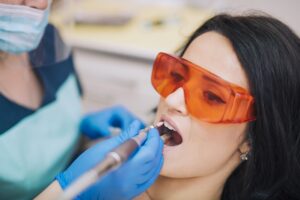dentist curing teeth patient glasses