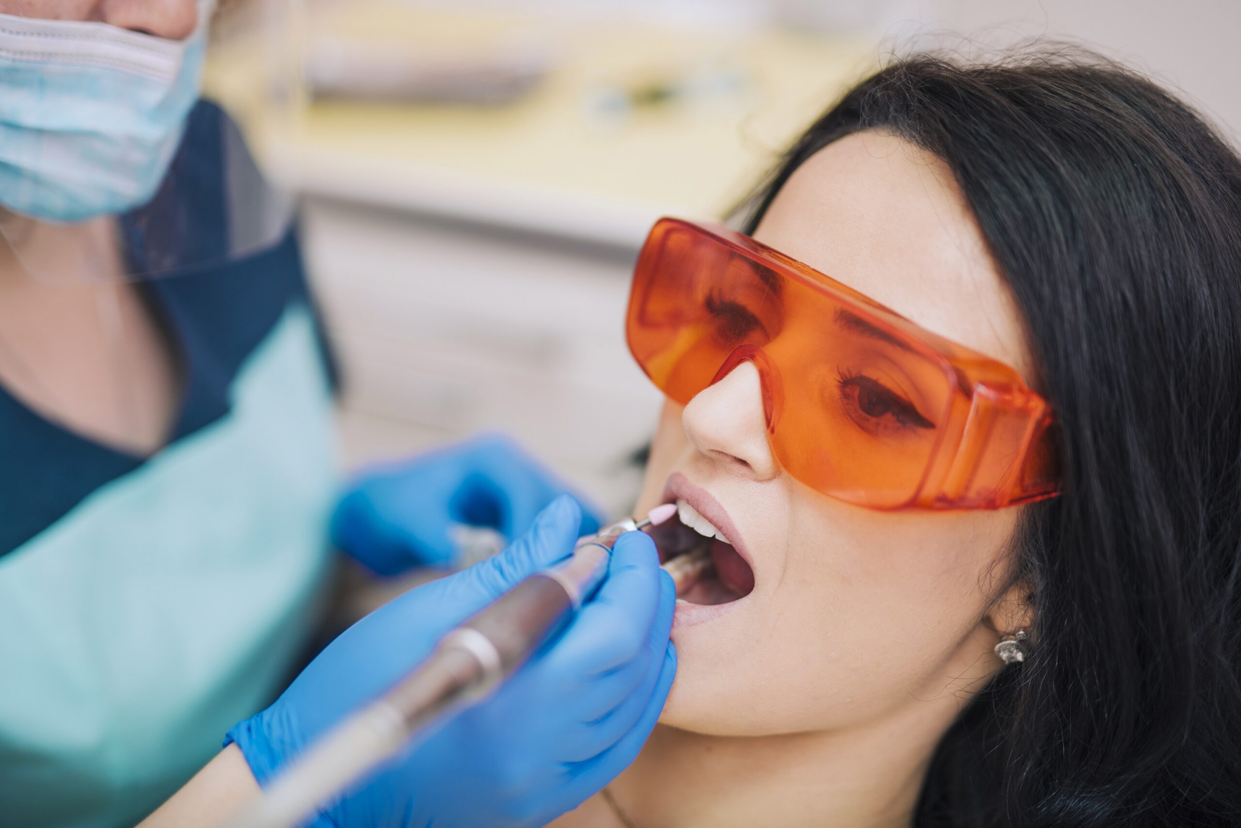 dentist curing teeth patient glasses