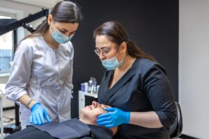 Team of female dentists treating patient's teeth.